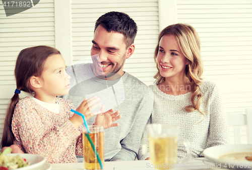 Image of happy family having dinner at restaurant or cafe