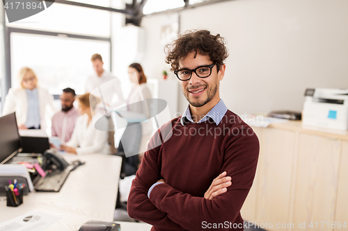 Image of happy young man over creative team in office