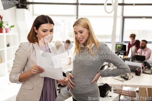Image of happy business team with papers in office