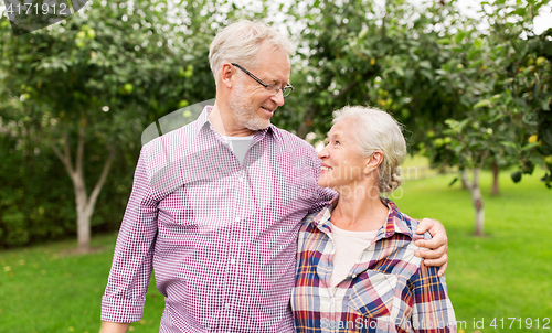 Image of happy senior couple hugging at summer garden