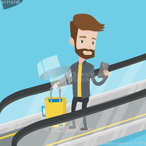 Image of Man using smartphone on escalator in airport.