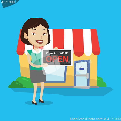 Image of Female shop owner holding open signboard.