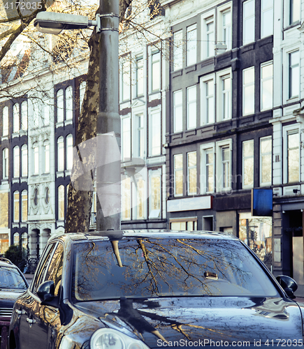 Image of european parking, cars on background with Amsterdam facade sunny day