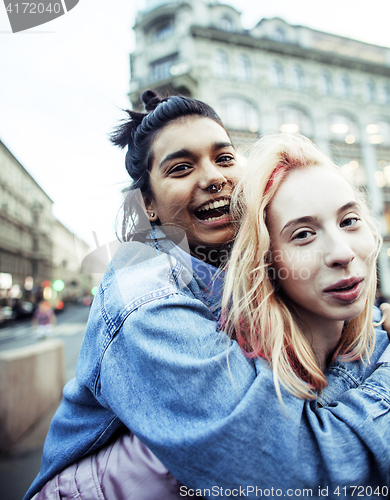 Image of Two teenage girls infront of university building smiling, having