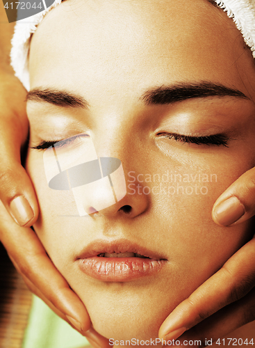 Image of stock photo attractive lady getting spa treatment in salon, close up asian hands on face