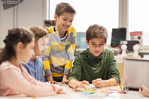 Image of happy children building robots at robotics school