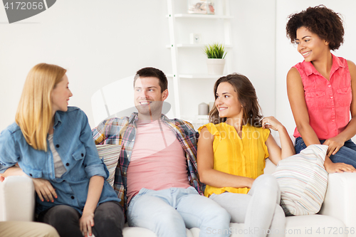 Image of group of happy friends talking at home