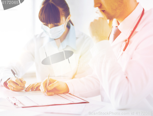 Image of doctor and nurse writing prescription paper