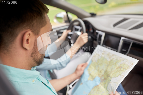 Image of couple driving in car with travel map