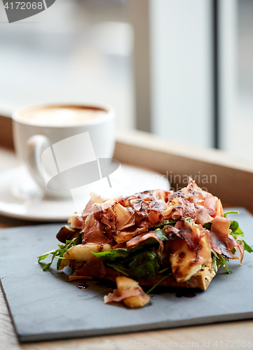 Image of prosciutto ham salad on stone plate at restaurant
