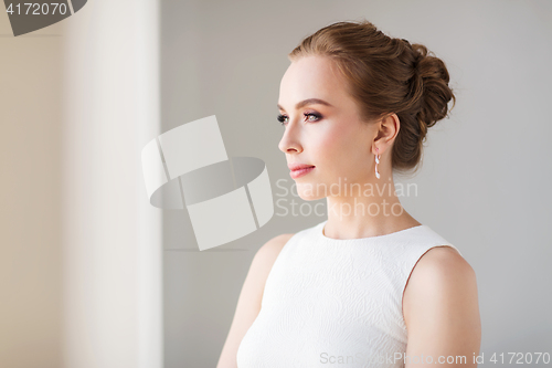 Image of smiling woman in white dress with diamond jewelry