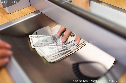 Image of clerk giving cash money to customer at bank office