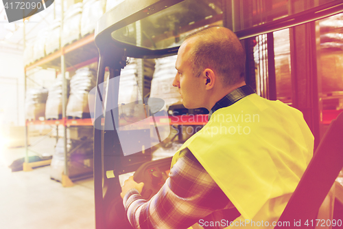 Image of man operating forklift loader at warehouse