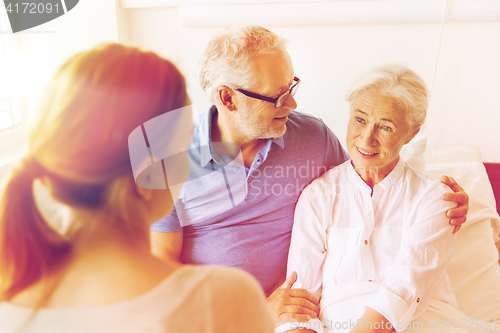 Image of happy family visiting senior woman at hospital