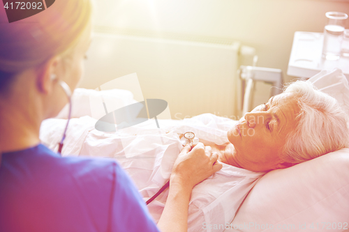 Image of nurse with stethoscope and senior woman at clinic