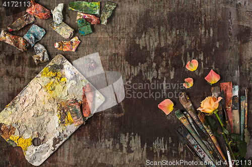 Image of paint brushes and tubes of oil paints on wooden background