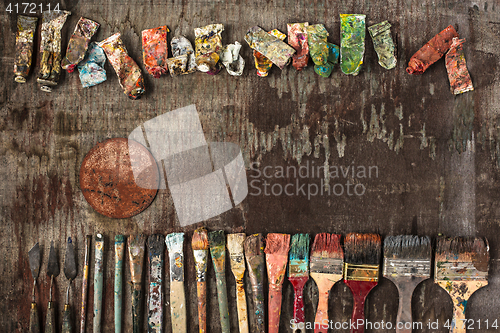 Image of paint brushes and tubes of oil paints on wooden background