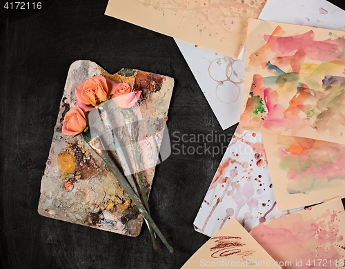 Image of paint brushes and tubes of oil paints on wooden background