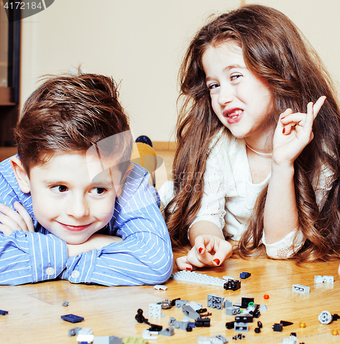 Image of funny cute children playing lego at home, boys and girl smiling, first education role lifestyle close up
