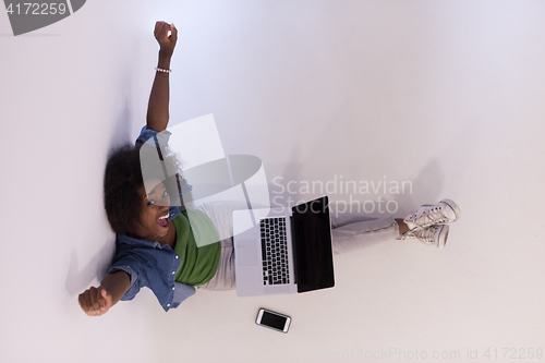 Image of african american woman sitting on floor with laptop top view