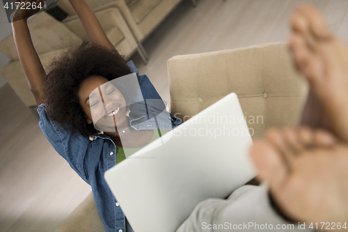 Image of African American women at home in the chair using a laptop