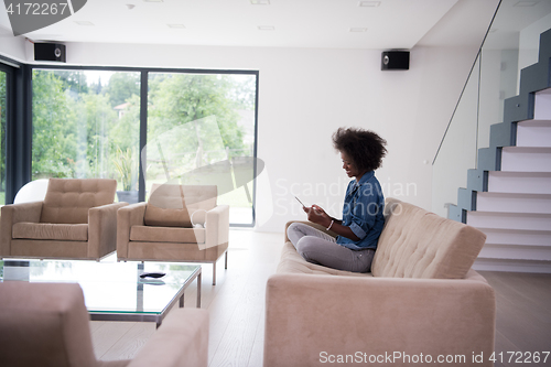 Image of african american woman at home with digital tablet