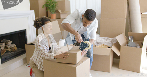 Image of Young couple packing boxes to move home
