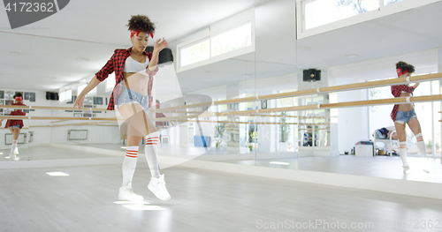 Image of Female dancing student takes steps in studio