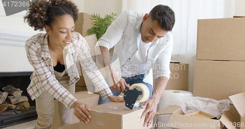 Image of Couple taping boxes as they pack up their home