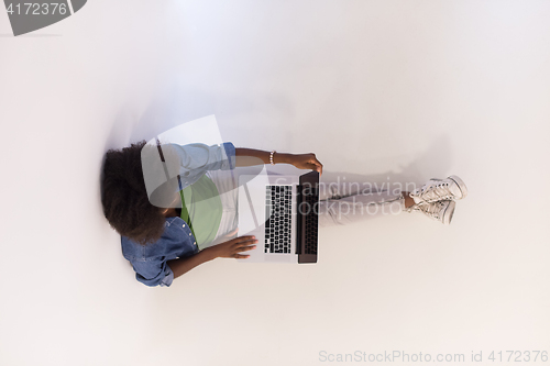 Image of african american woman sitting on floor with laptop top view