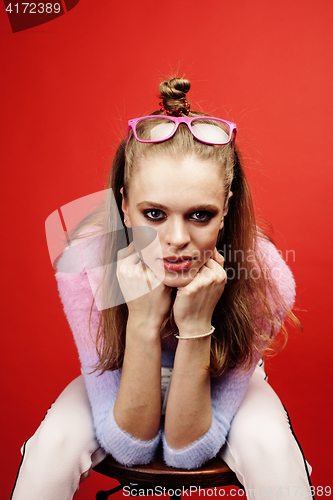Image of young pretty emitonal posing teenage girl on bright red background, happy smiling lifestyle people concept 