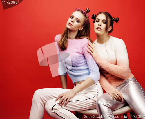 Image of two best friends teenage girls together having fun, posing emotional on red background, besties happy smiling, lifestyle people concept 