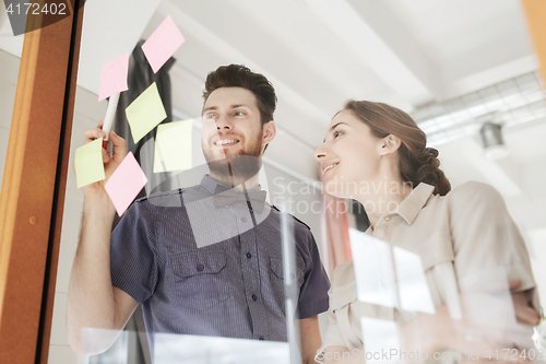 Image of creative team with stickers on glass at office