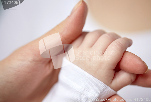 Image of close up of mother and newborn baby hands