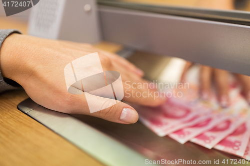 Image of clerk giving cash money to customer at bank office