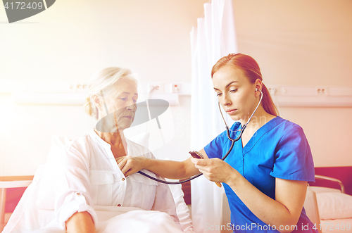 Image of nurse with stethoscope and senior woman at clinic