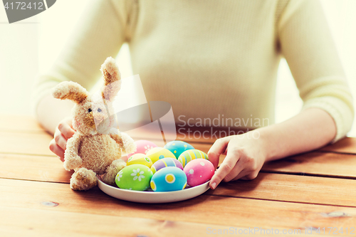 Image of close up of woman hands with easter eggs and bunny