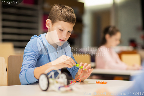 Image of close up of boy building robot at robotics school