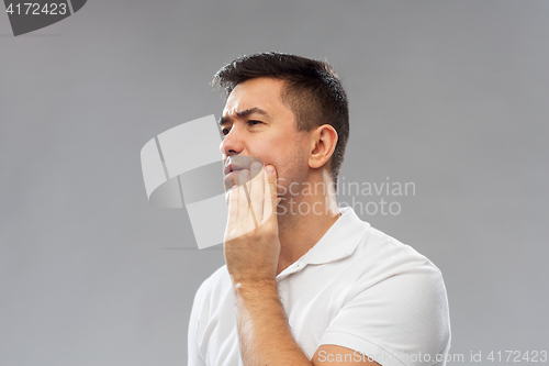 Image of unhappy man suffering toothache