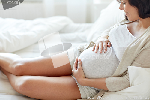 Image of close up of happy pregnant woman in bed at home