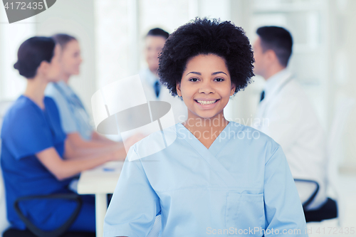 Image of happy doctor over group of medics at hospital