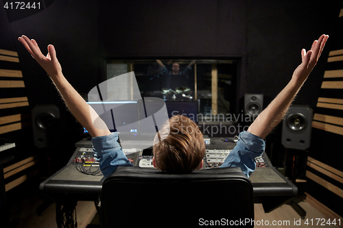 Image of man at mixing console in music recording studio