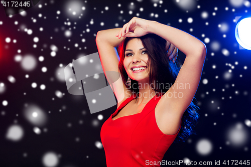 Image of beautiful sexy woman in red dancing at nightclub