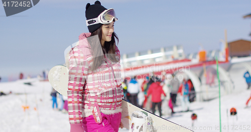 Image of Cute and happy female asian snowboarder