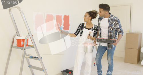 Image of Young couple discussing shades of paint color