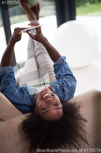 Image of african american woman at home with digital tablet