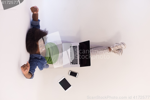 Image of african american woman sitting on floor with laptop top view