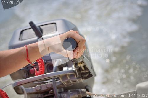 Image of Fisherman hand and boat engine