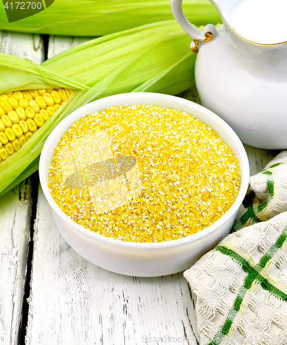 Image of Corn grits in bowl with milk on board