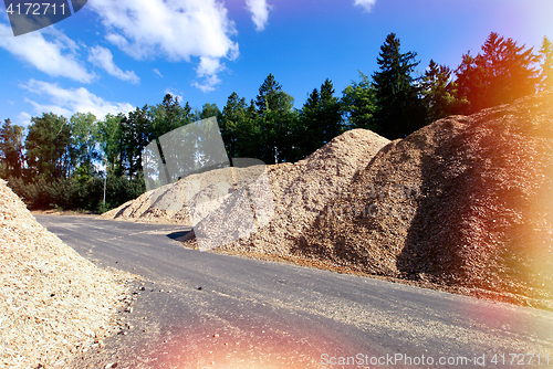 Image of storage of wooden fuel against blue sky